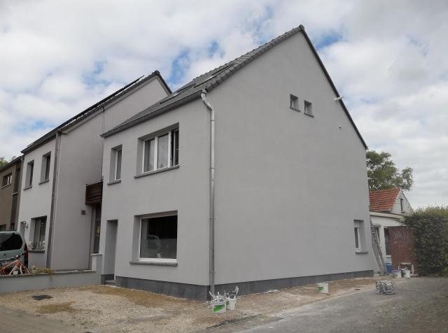 Grijs gepleisterde woningen aan de straat