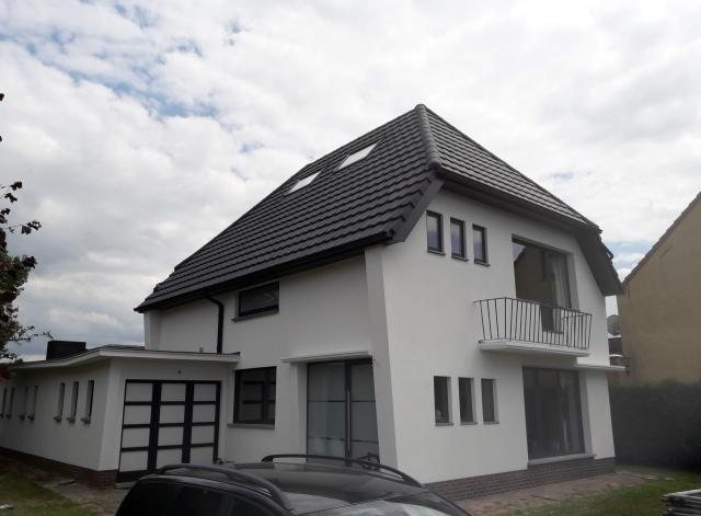 Gepleisterde woning met zwart dak in Baasrode