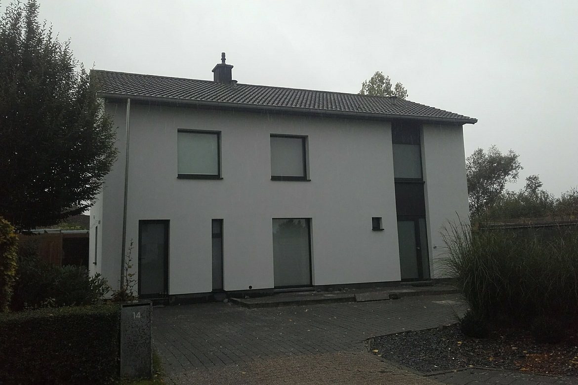 Wit gepleisterde woning met een grijze plint